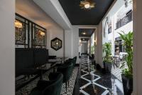 a restaurant with black tables and green chairs at Liu Men Melaka in Melaka