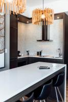 a kitchen with a large white counter and chairs at Entourage sur-le-Lac in Lac-Beauport