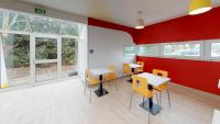 a room with tables and chairs and red walls at Première Classe Reims Ouest - Tinqueux in Reims