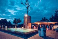 a group of people standing around a pool at night at Hotel Rural Xereca in Puig D’en Valls