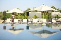 a man sitting in a chair next to a swimming pool at Hotel Rural Xereca in Puig D’en Valls
