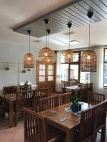 Un restaurante con mesas y sillas de madera y lámparas de araña. en Resort-Restaurant Stilec, en Kamenný Újezd
