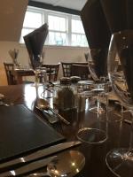 una mesa de madera con copas de vino y servilletas. en The Mill House Hotel, en Buckie