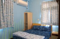 a small bedroom with a bed and curtains at The Beauty of Basalt B&amp;B in Magong