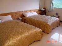 a hotel room with two beds and a window at Feng Lin Homestay in Shuili