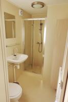 a bathroom with a shower and a toilet and a sink at Camping Bissen in Esch-sur-Sûre