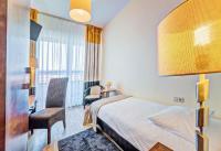 ein Hotelzimmer mit einem Bett, einem Schreibtisch und einem Stuhl in der Unterkunft Don Prestige Residence in Posen