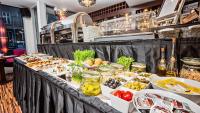 ein Buffettisch mit vielen verschiedenen Arten von Speisen in der Unterkunft Don Prestige Residence in Posen