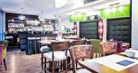ein Restaurant mit Tischen und Stühlen und einer Bar in der Unterkunft Don Prestige Residence in Posen