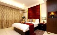 a bedroom with a large bed with a red headboard at Simplicity Sojourn Hualien in Hualien City