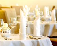 a table with white clothed tables with wine glasses at Hotel Kolonada in Karlovy Vary