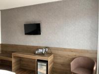 a room with a table and a tv on a wall at F Hotel in Hörsching