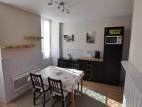 a kitchen with a table and chairs and a microwave at Appartement de la cascade in Eaux-Bonnes