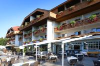 una vista exterior de un hotel con mesas y sillas en Dei Hotel Schönblick, en Velden am Wörthersee
