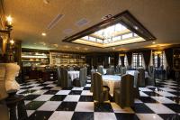 a restaurant with tables and chairs on a checkered floor at The Old England Manor in Ren&#39;ai