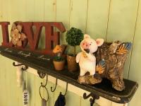 a shelf with a pig figurine and plants on it at Fazhana Village B&amp;B in Hualien City