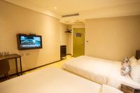 a hotel room with two beds and a tv on the wall at Just Live Inn-Taipei Station in Taipei