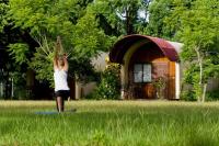 a woman doing yoga in the grass in front of a house at Ville Greensward in Taitung City