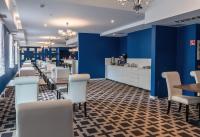 Hotel Sękowski في ليجنيكا: غرفة طعام بجدران زرقاء وطاولات وكراسي