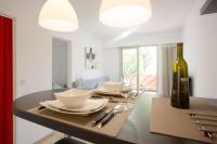 a dining room with a table with glasses and a bottle of wine at Dans un écrin de verdure in Hyères