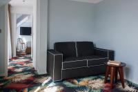 a black couch in a living room with a table at Hotel Eiffel Blomet in Paris