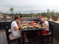 Un grupo de personas sentadas en una mesa comiendo comida en Sweet Home, en Chitwan