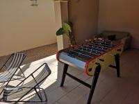 a ping pong table in a living room with two chairs at Le Mas des Geais in Atur