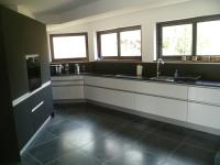 a kitchen with black and white counters and windows at VILLA KB&#39;HOME in Le Touquet-Paris-Plage