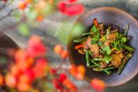 a plate of food on a table with flowers at No.5 Valley Lodge in Zhangjiajie