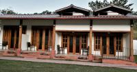 a small house with wooden doors and windows at Panama Camping Park Boquete in Boquete