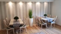 a dining room with two tables and chairs and plants at Pension Gockels-Auszeit in Bad Wildungen