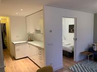 eine Küche mit weißen Schränken und ein Bett in einem Zimmer in der Unterkunft Kangaroom in Amsterdam