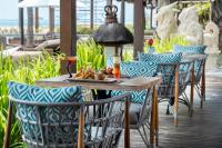 uma mesa e cadeiras com um prato de comida sobre ela em Griya Santrian a Beach Resort And Spa em Sanur