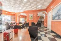 a restaurant with orange walls and tables and chairs at Hotel La Parrita in Rota