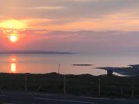 a sunset over a body of water with the ocean at Zepher Apartment in Doolin