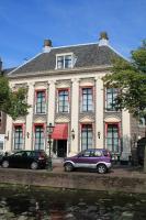 una casa con dos coches estacionados frente a ella en De Doelen, en Leiden