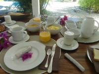 una mesa con platos de comida y tazas de zumo de naranja en villa ambralini, en Saint-Pierre