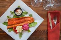 un piatto bianco con del pesce sopra un tavolo di Summit Mountain Lodge and Steakhouse a East Glacier Park