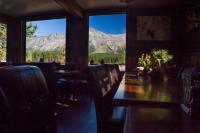 un ristorante con tavolo, sedie e montagne di Summit Mountain Lodge and Steakhouse a East Glacier Park