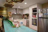 a kitchen with white cabinets and a stainless steel refrigerator at Hualien Wow Hostel in Hualien City