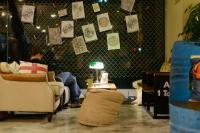 a man sitting on a couch in a living room at Hualien Wow Hostel in Hualien City