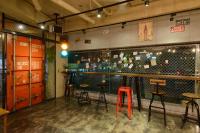 a bar with tables and stools in a room at Hualien Wow Hostel in Hualien City