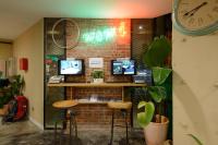a room with a brick wall with a bar with a clock at Hualien Wow Hostel in Hualien City