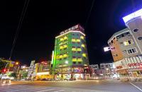 a tall green building on a city street at night at Hualien Wow Hostel in Hualien City