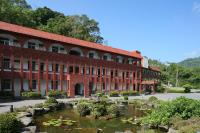 a building with a pond of water lilies at Rainbow Resort Hotel in Wenquan