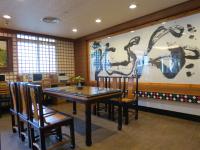 a dining room with a table and chairs and a painting at Rainbow Resort Hotel in Wenquan