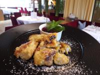a black plate with food on a table at Gesundhotel Bad Reuthe in Vorderreuthe