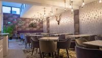 Un restaurante con mesas y sillas en una sala. en ART Hotel, en Sibiu