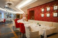 ザールバッハ・ヒンターグレムにあるHotel Alpine Palaceの白いテーブルと赤い壁のレストラン