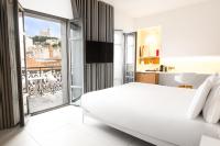 a bedroom with a white bed and a balcony at Hotel C2 in Marseille